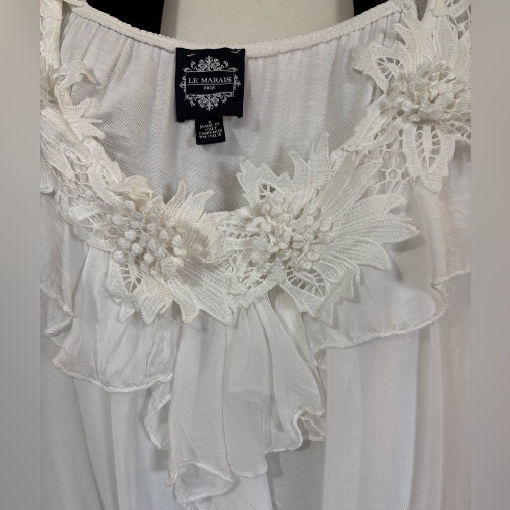 White silk made in Italy blouse. 3D flowers at v neckline. Ruffle front.